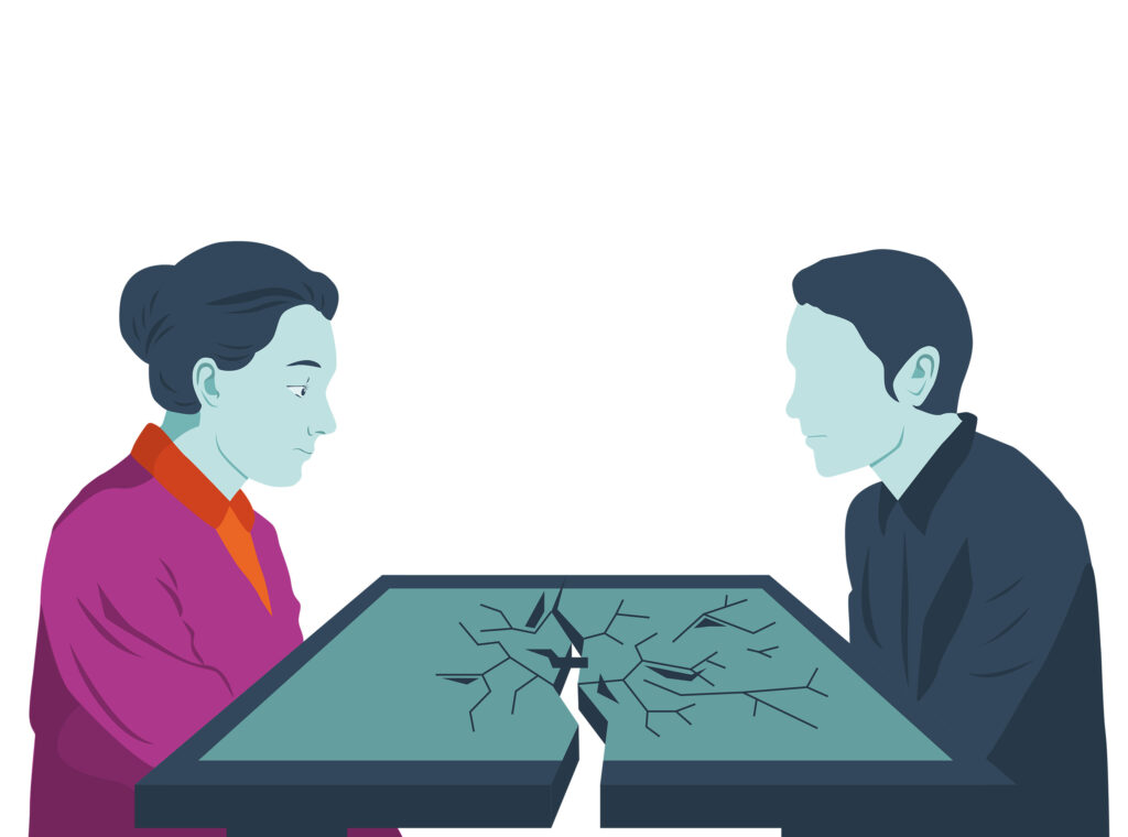 Zwei Personen blicken sich über einen zerbrochenen Tisch an.